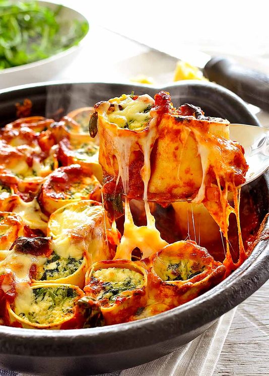 勺子举起菠菜和乳清干酪rotolo  - 奶酪拉！