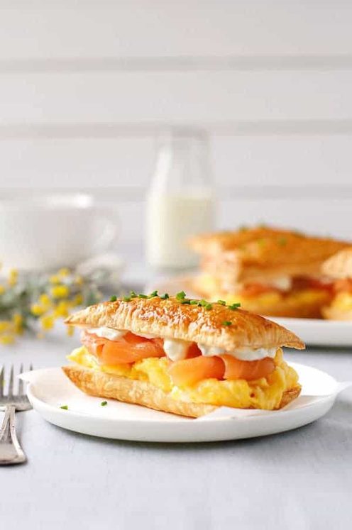 熏制的三文鱼和鸡蛋早餐在一块白色板材的米勒 - 费尔勒