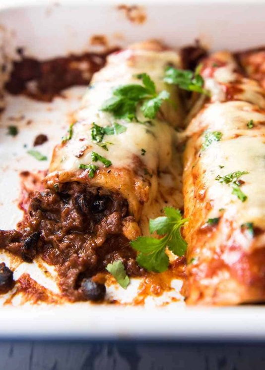 关闭牛肉echiladas在烘烤盘，新鲜从烤箱外面