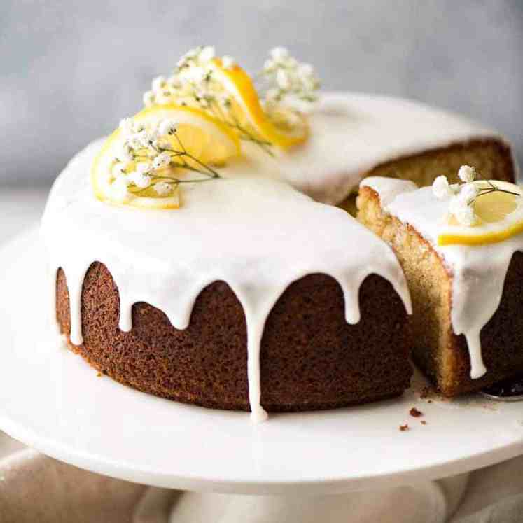 柠檬蛋糕，上面有柠檬片和柠檬花，白色的蛋糕盘上切了一块