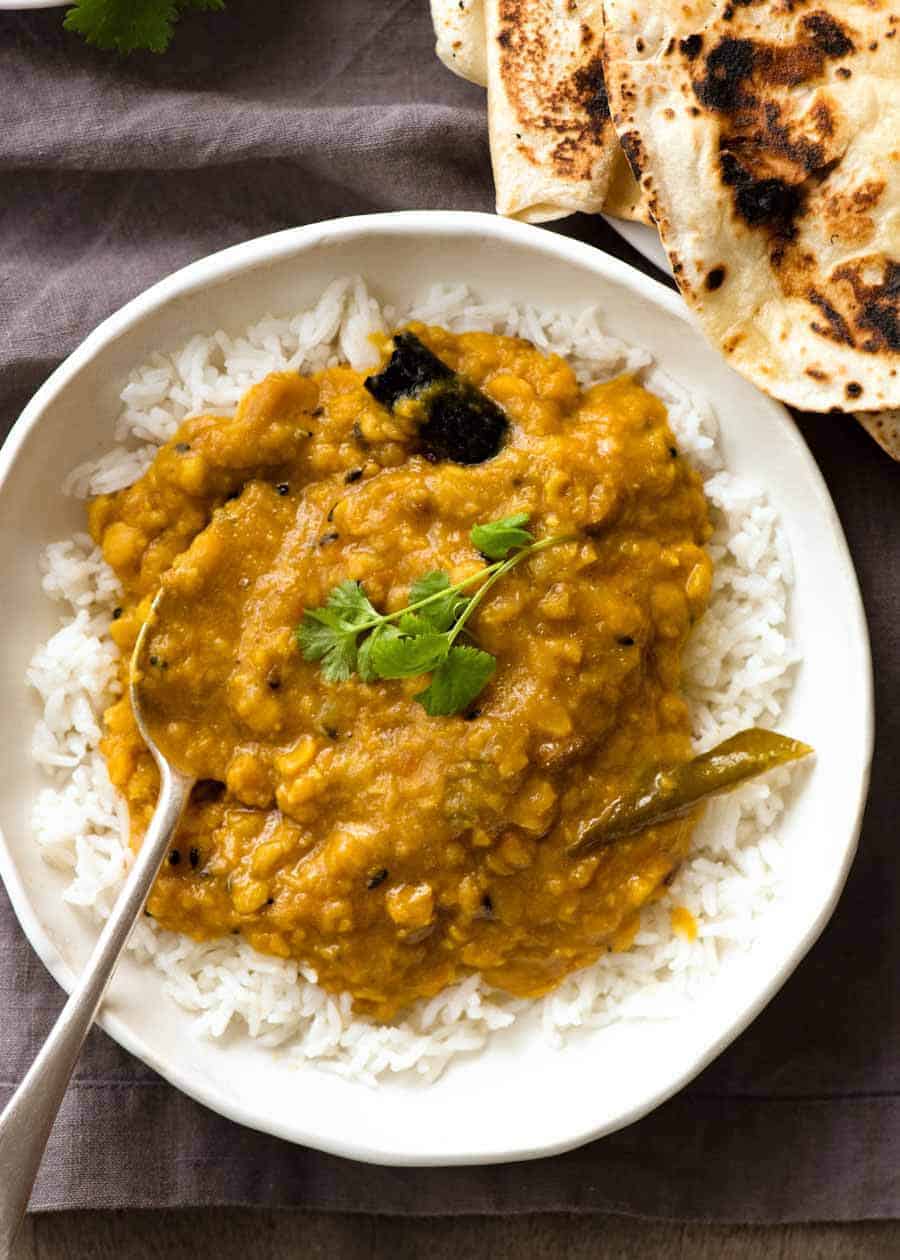 自创印度扁豆咖喱（Dal）顶上的照片在一块土气白色碗的米饭用了chapati的一侧，准备被吃。