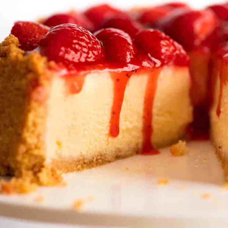 草莓芝士蛋糕的特写镜头，草莓酱滴在边上