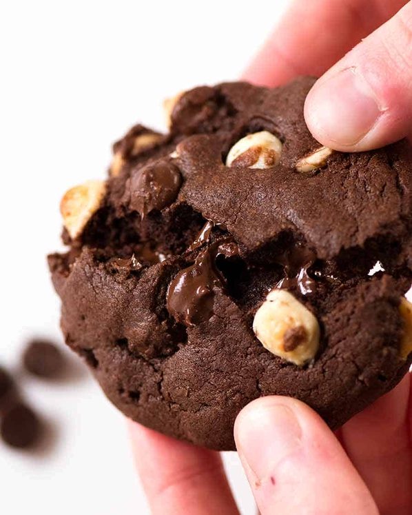 手打破一个比拜伦湾更好的三重巧克力饼干的特写。里面有嚼劲，40%的巧克力，边缘酥脆。