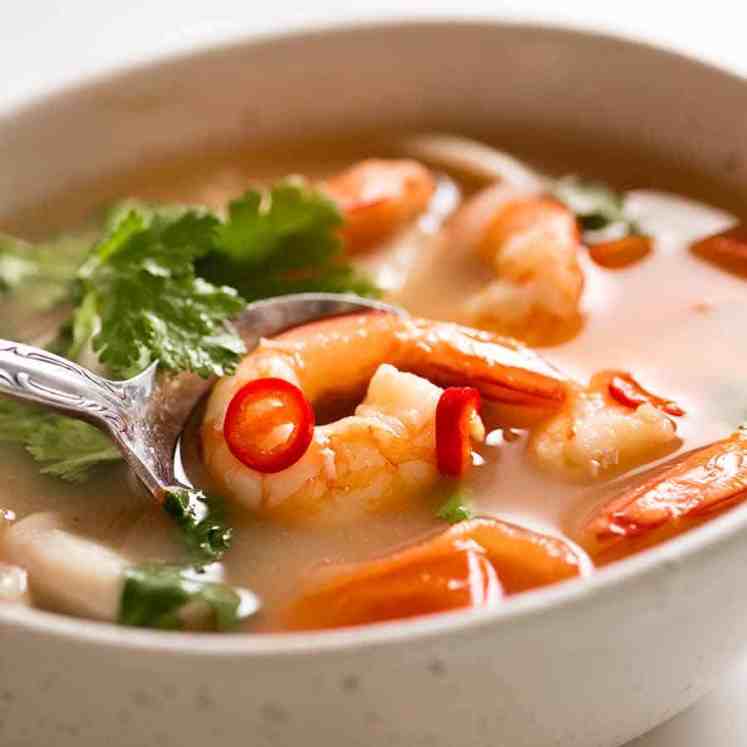 白色碗用汤姆yum汤（泰国汤）用大虾/虾，蘑菇，蕃茄和装饰与香菜和辣椒