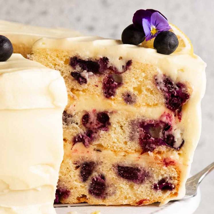 切片蓝莓蛋糕用柠檬奶油乳酪结霜在板材
