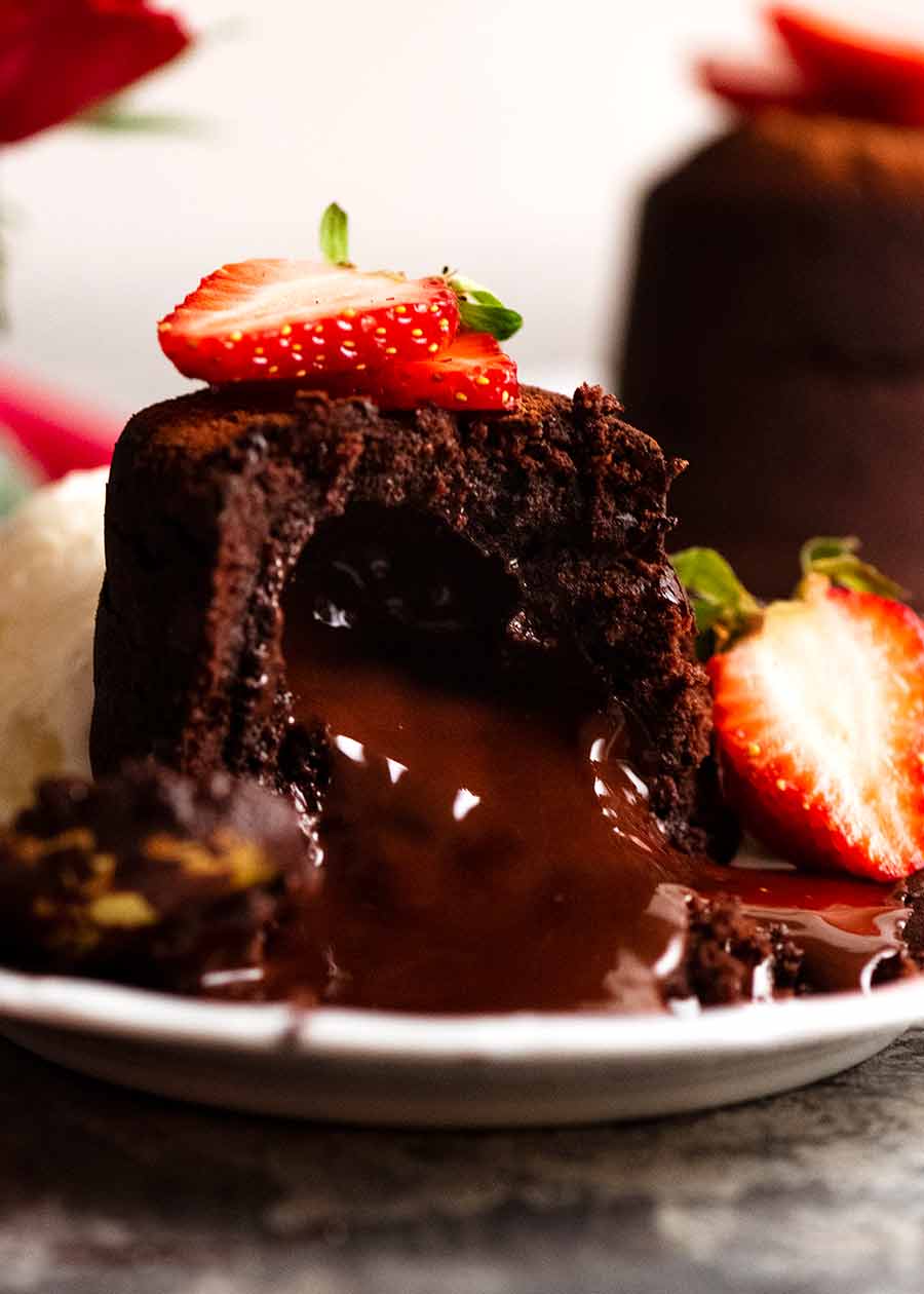 关闭熔化巧克力蛋糕用倾吐的巧克力熔岩，装饰用草莓GydF4y2Ba